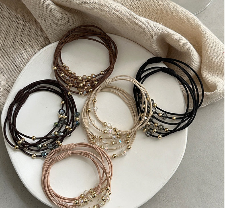 Durable Hair Rope Adult Hair Elastic Bands in black, brown, beige, and khaki displayed on a white plate, ideal for stylish ponytails.