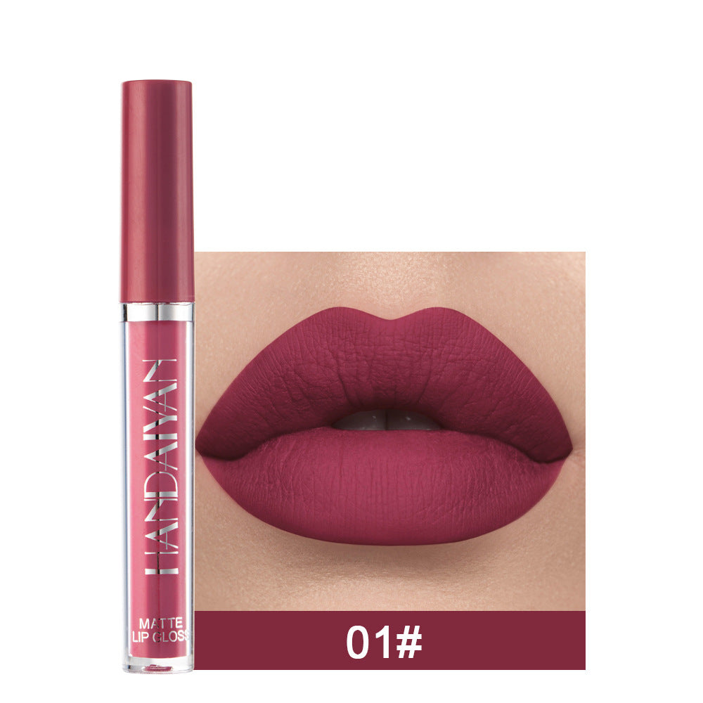 Lipstick with a close-up of lips wearing the color on a beige background
