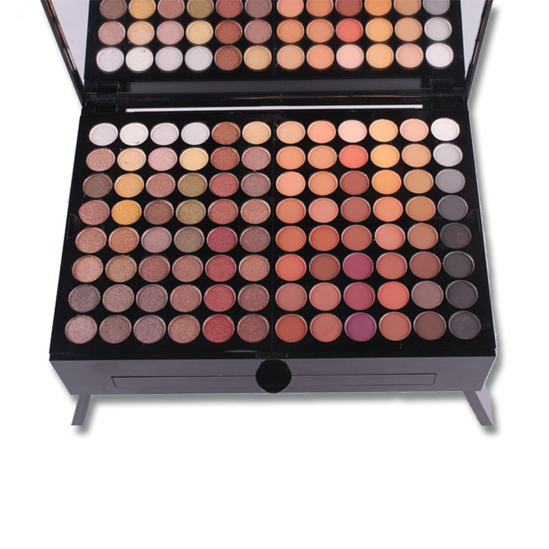 Makeup palette with various eyeshadow colors on a white background
