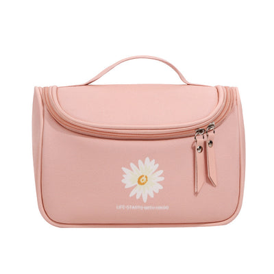 Pink toiletry bag with a white daisy design and text on a white background