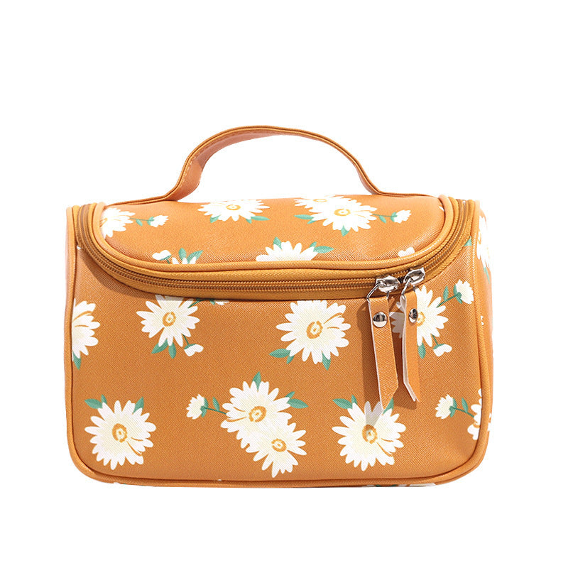 Orange toiletry bag with white floral pattern on a white background