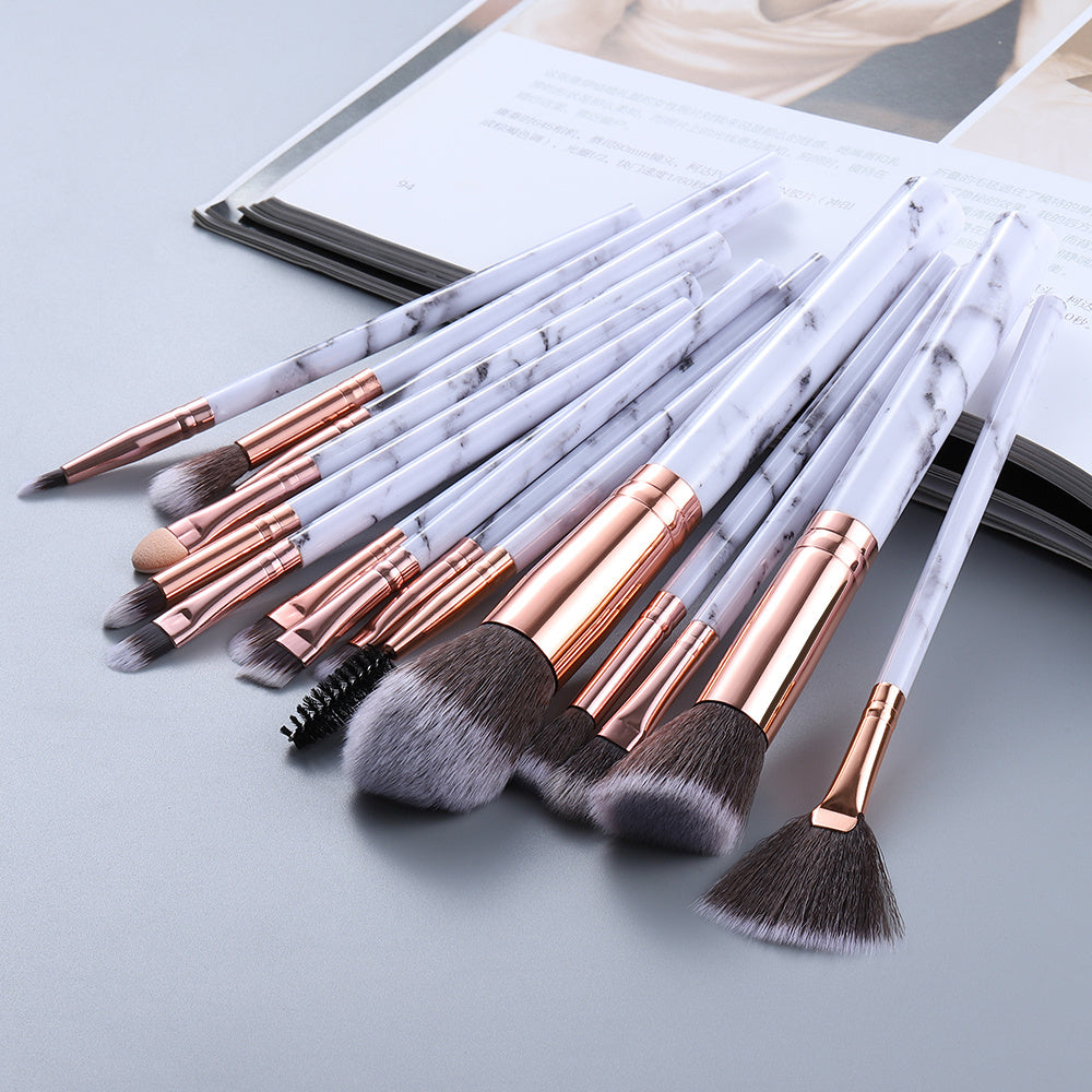 Set of makeup brushes with marble handle design on a light gray background