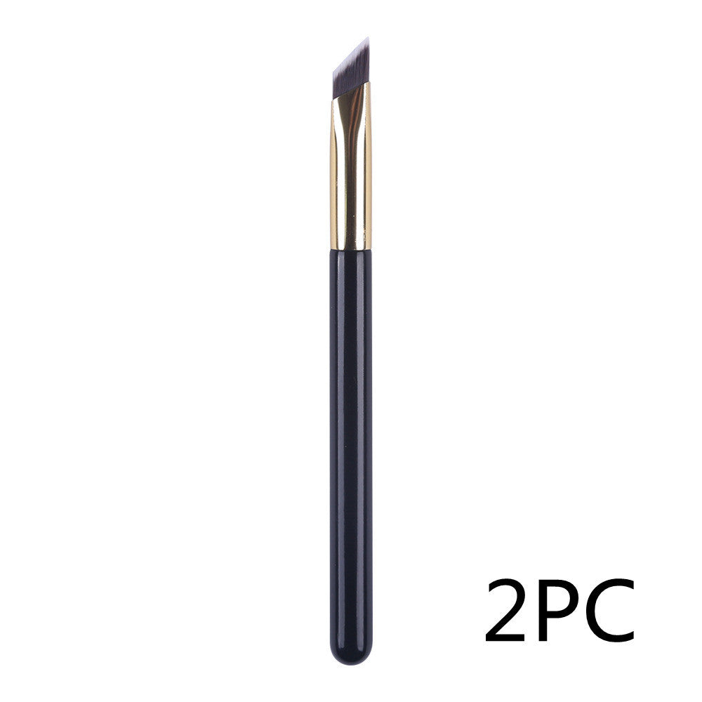 Eyebrow brush with black handle and gold accents on a white background, labeled '2PC'.