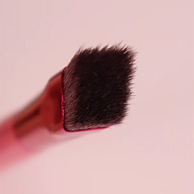 Makeup brush with black bristles on a pink background