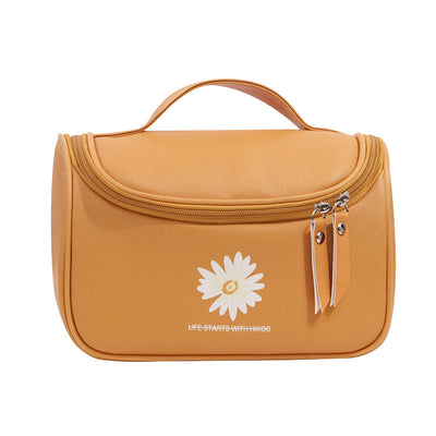 Orange toiletry bag with a white daisy logo on a white background