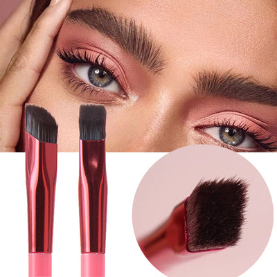 Makeup brushes with pink handles and black bristles, shown with a close-up of a brush head on a white background.