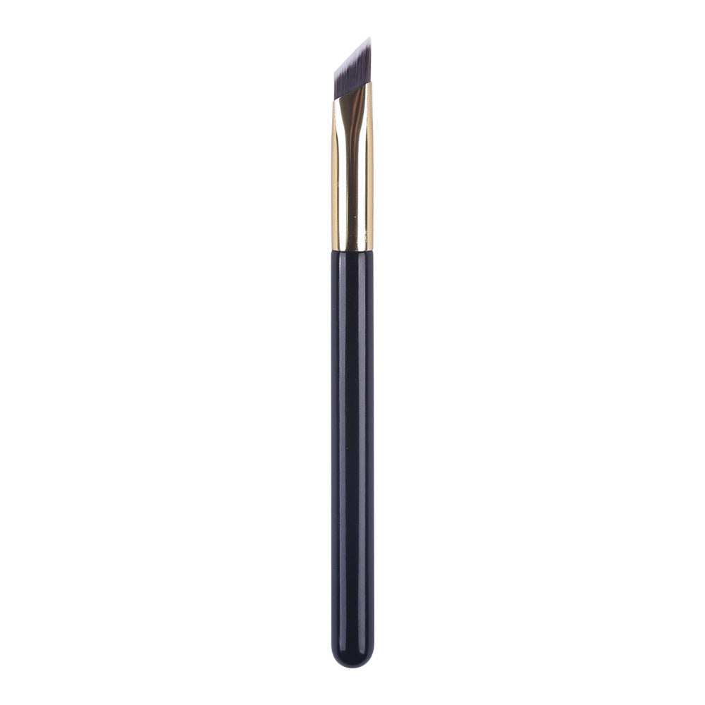 Eyebrow brush with black handle and gold ferrule on a white background