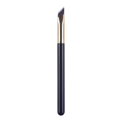 Eyebrow brush with black handle and gold ferrule on a white background