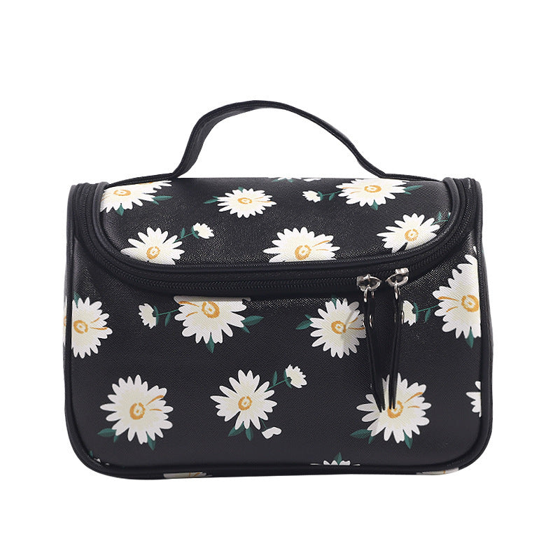 Black toiletry bag with white floral pattern on a white background